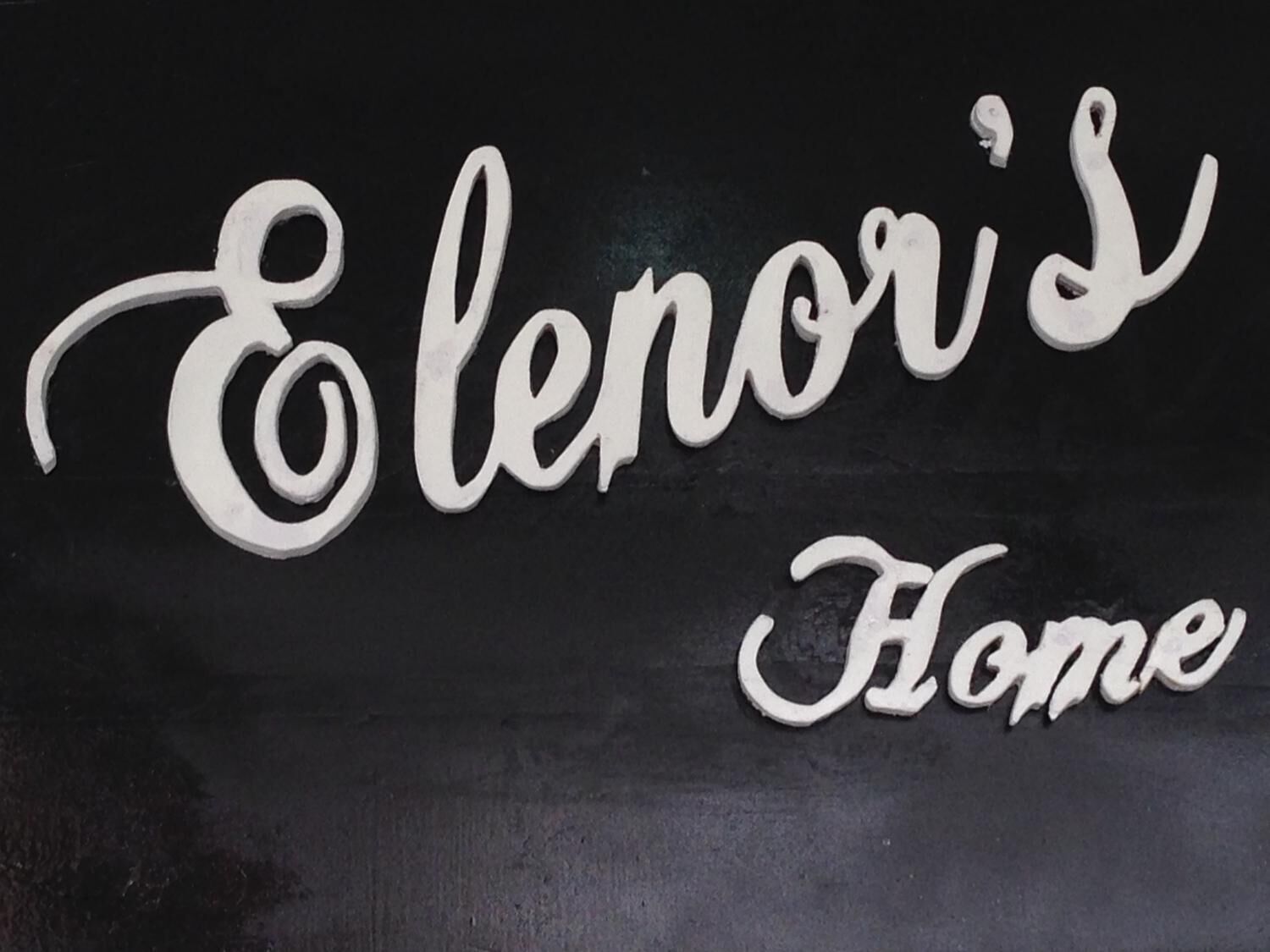 Un senyal amb el text 'Elenor's Home' en una lletra cursiva.