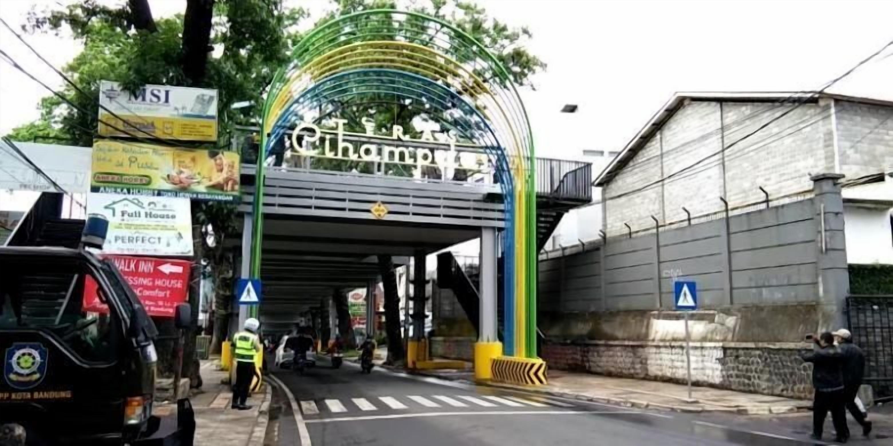 A hotel entrance with a green archway and multiple signs, including one for 'Full House'.