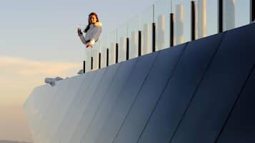 A person standing on a modern building with a glass facade.