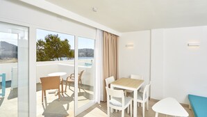 A modern room with a balcony, a dining table with chairs, and a sofa. - Sun Beach (Calvia)