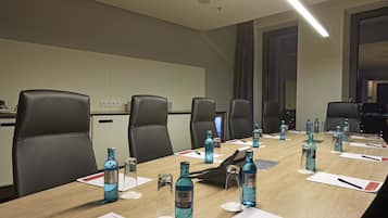 A conference room with a long table, multiple chairs, and water bottles.
