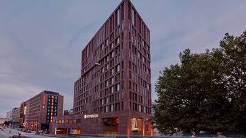 Un hotel moderno con un llamativo letrero 'Hyperion', que presenta una fachada con entramado y numerosas ventanas.