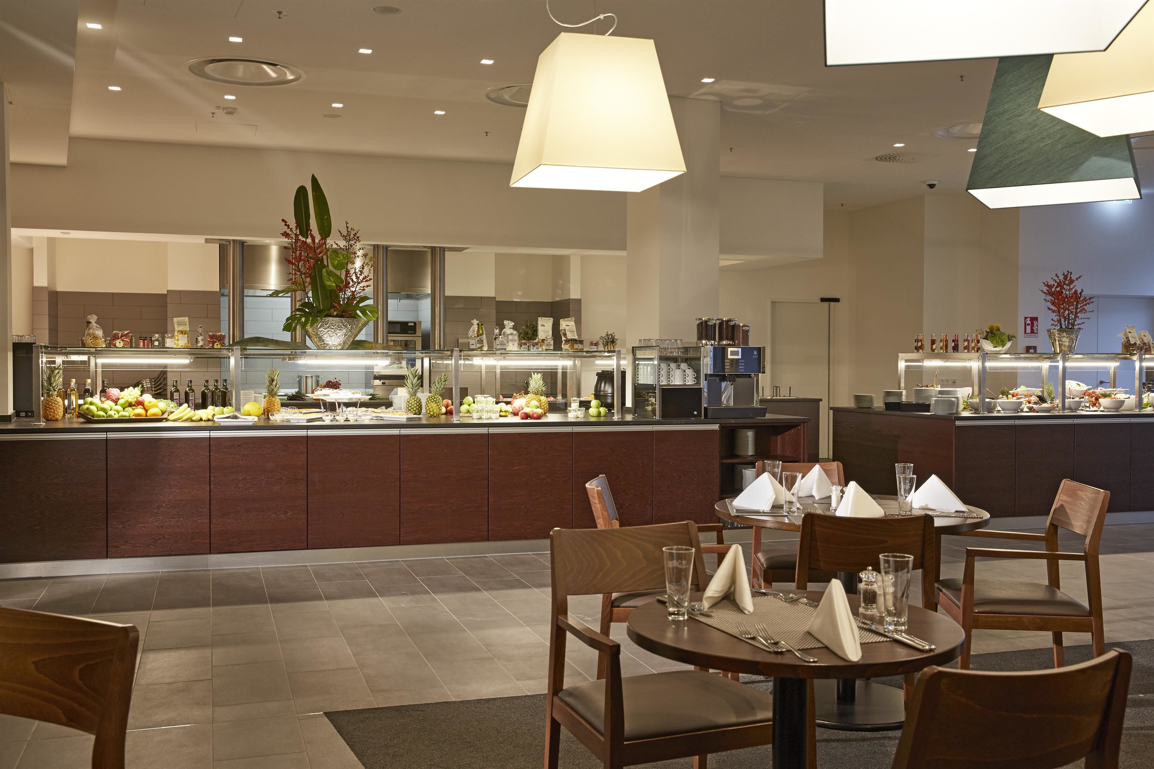 Eine moderne Hotelküche mit einer zentralen Kochinsel, ausgestattet mit verschiedenen Geräten und einer Obstauslage.