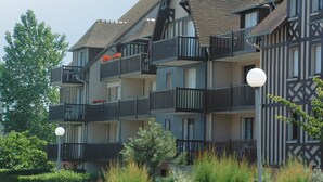 A multi-story building with balconies, a tiled roof, and a street lamp. - Résidence Lagrange Vacances Cabourg (Cabourg)