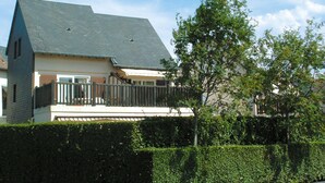 A two-story house with a balcony, a fenced yard, and a hedge in the foreground. - Résidence Lagrange Vacances Cabourg (Cabourg)