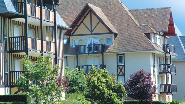 A row of traditional European-style buildings with multiple balconies and a mix of gabled and pitched roofs. - Résidence Lagrange Vacances Cabourg (Cabourg)