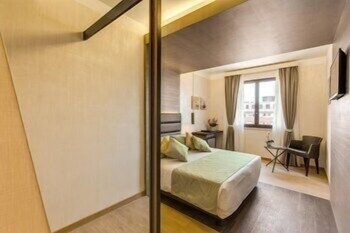 Una habitación de hotel moderna con una cama, un escritorio y una silla.