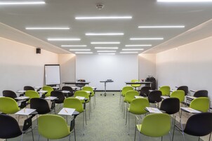 A classroom with rows of desks and chairs, a whiteboard, and a projector.