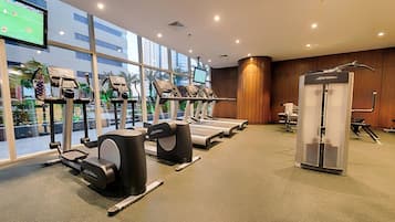 A gym with treadmills, elliptical machines, and a weight machine.