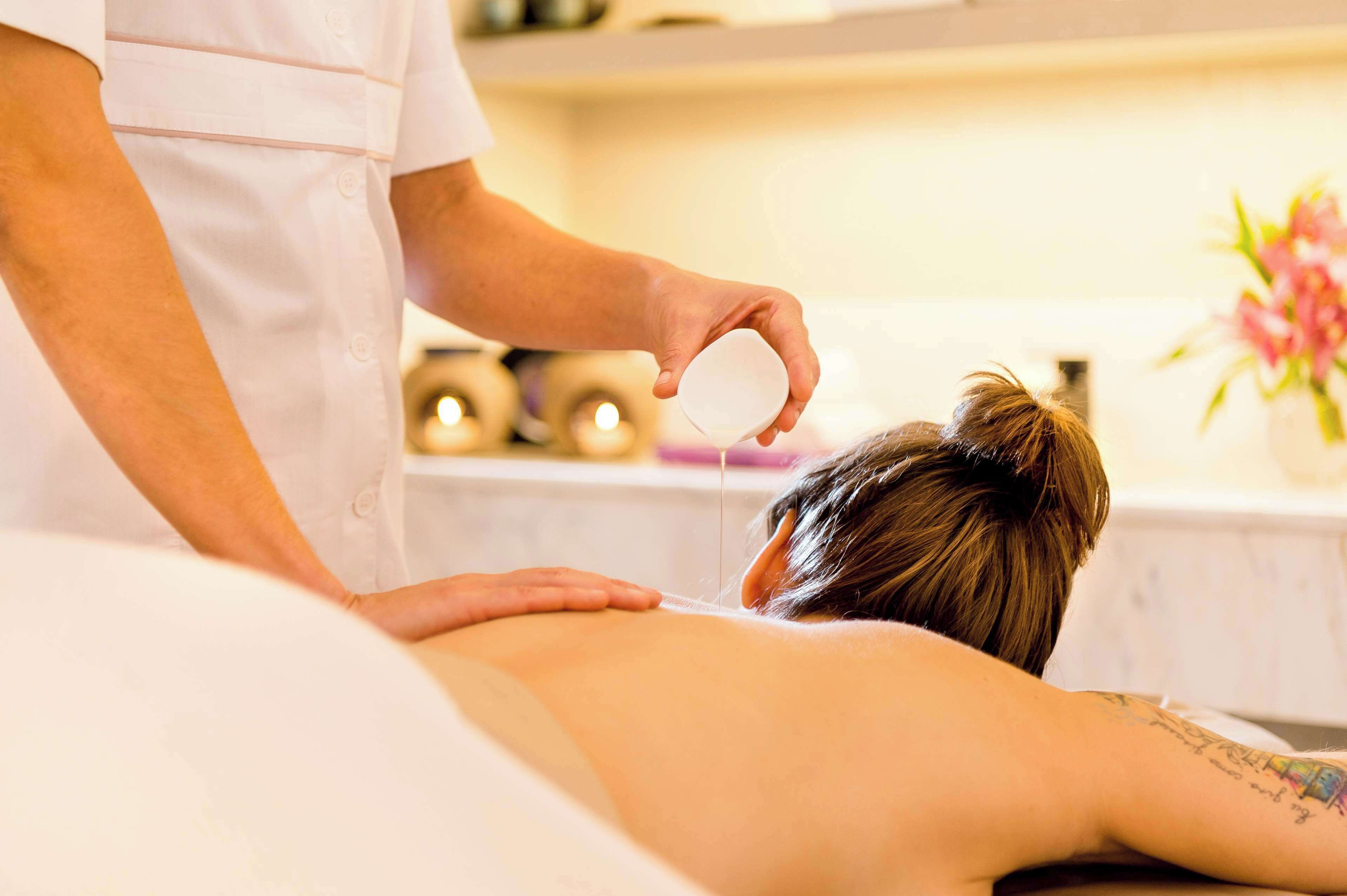 Uma pessoa recebendo um tratamento nas costas em um spa.