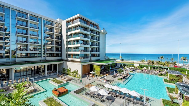 A modern hotel with multiple balconies, a large outdoor pool, and a view of the ocean. - Grand Hyatt Rio De Janeiro (Rio de Janeiro)