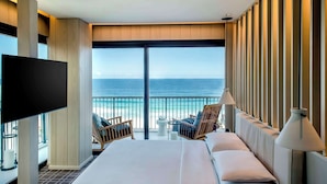 A hotel room with a large bed, a TV, a balcony with a view of the ocean, and a seating area with chairs and a table. - Grand Hyatt Rio De Janeiro (Rio de Janeiro)