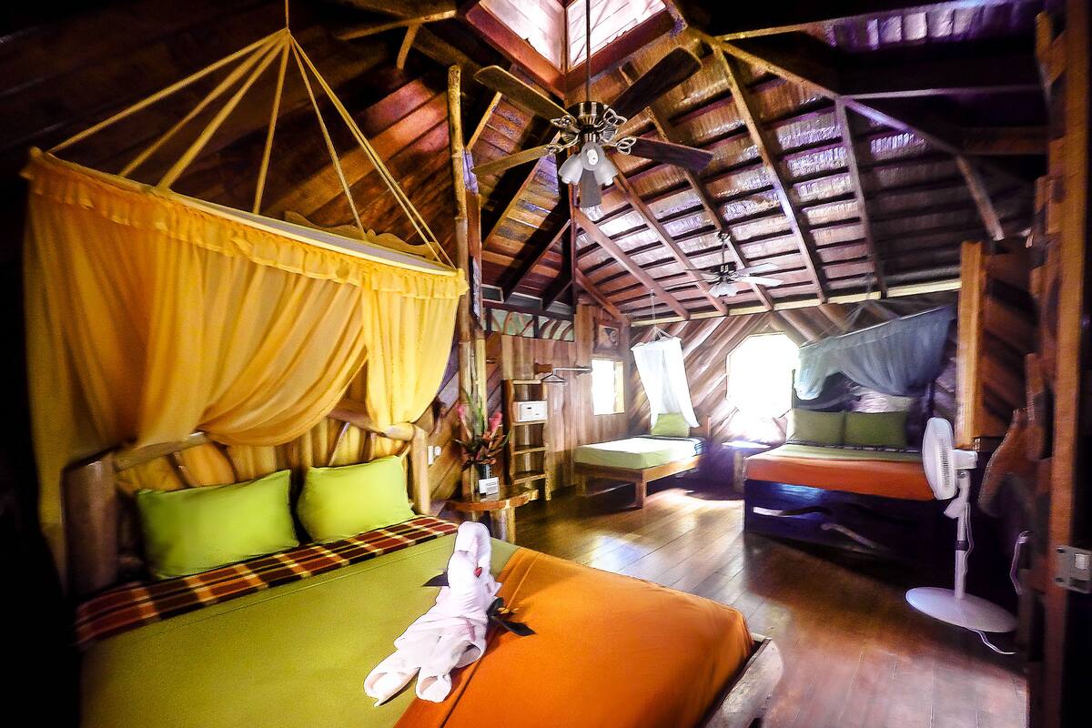 Una habitación con una cama, una silla, una mesita de noche y una ventana.