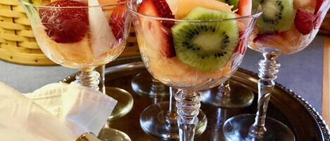 Three dessert glasses with fruit on a tray.
