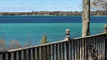 A wooden deck with a railing overlooking a lake.