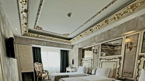 A hotel room with two beds, a chair, a desk, and a large mirror. - Hotel Buyuk Hamit (Istanbul)