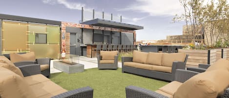 An outdoor seating area with wicker furniture and a barbecue grill.