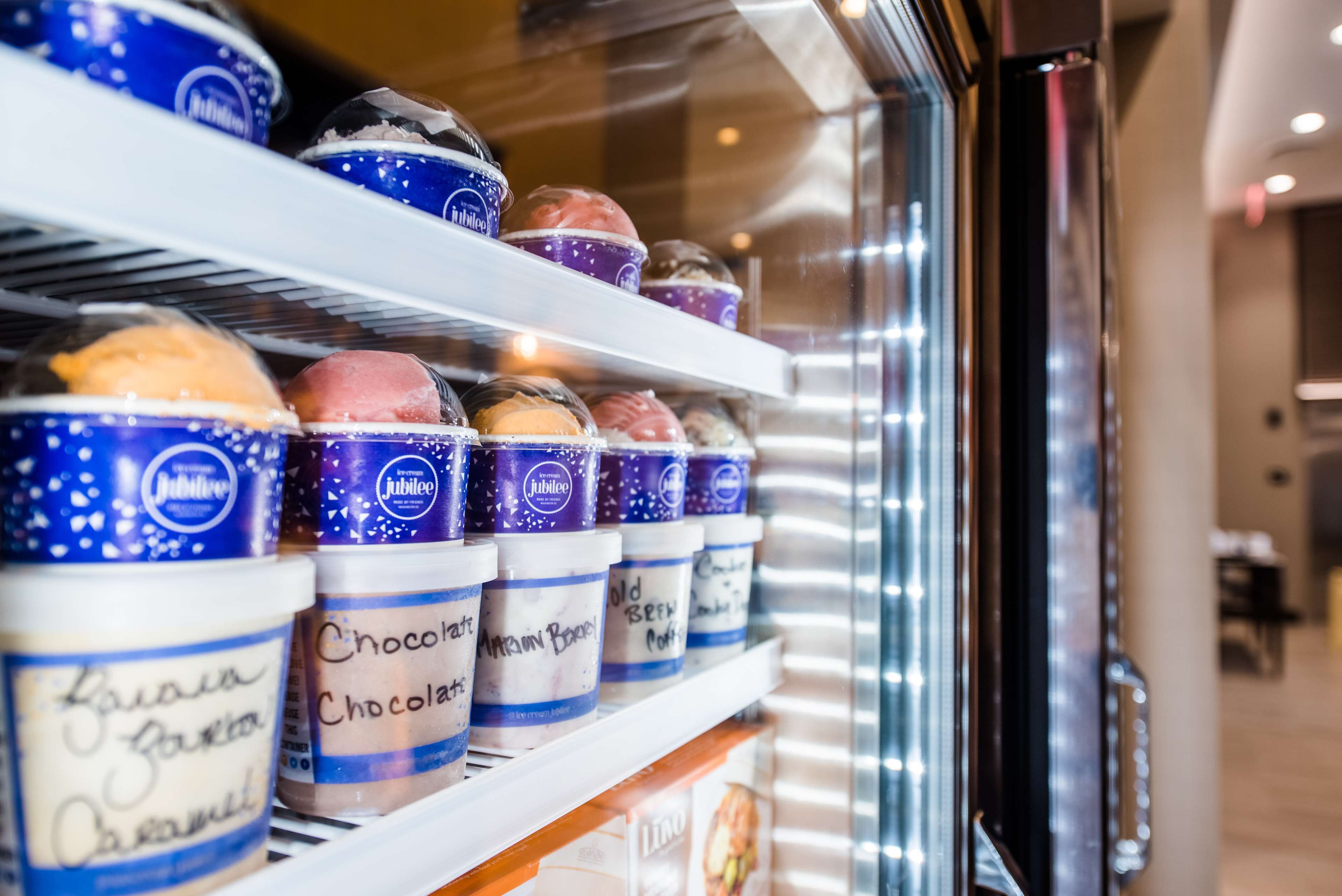 A refrigerated display case with various ice cream flavors in tubs.