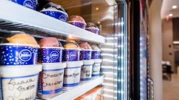 A refrigerated display case with various ice cream flavors in tubs.