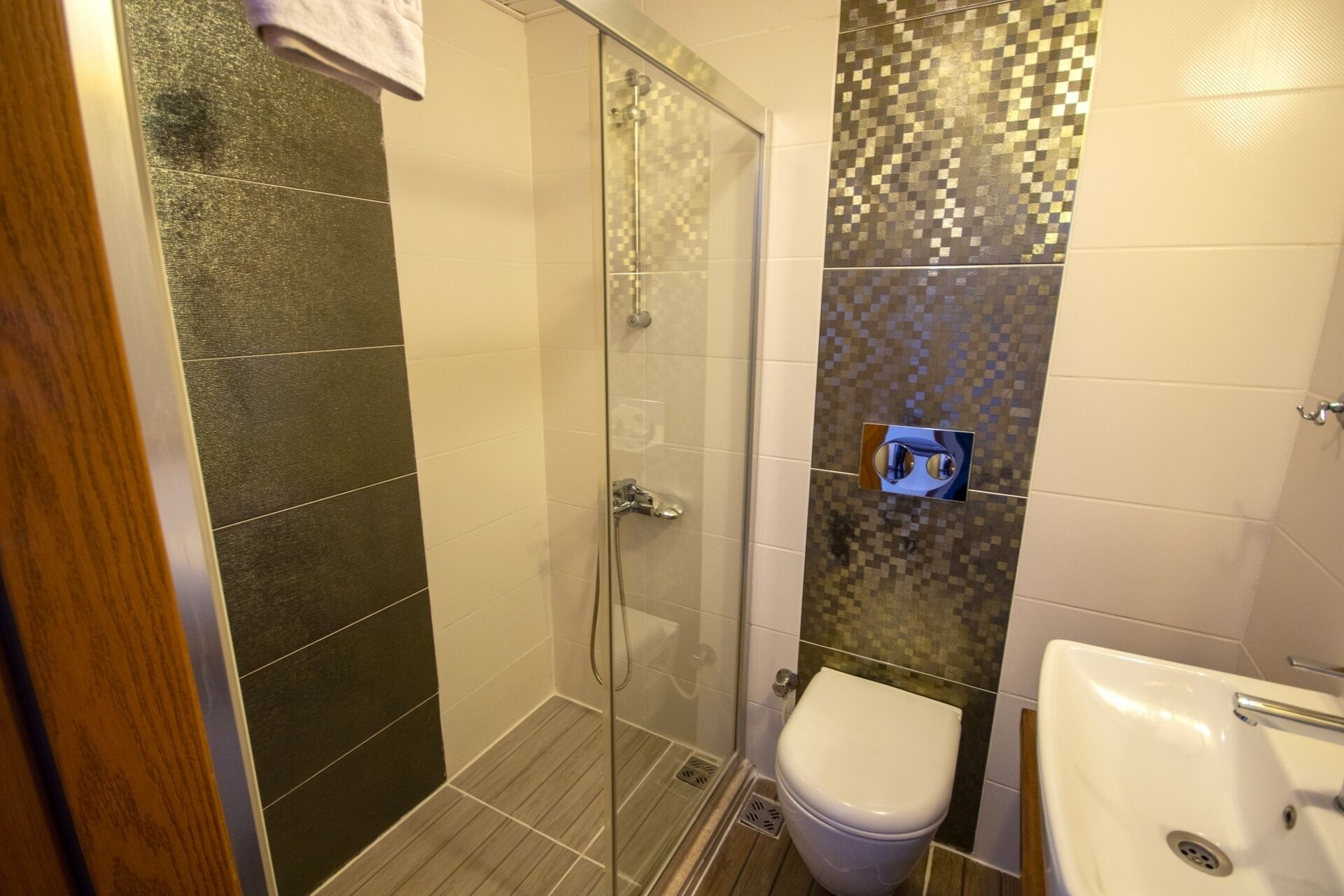Une salle de bain avec une douche à parois de verre, des toilettes et un lavabo.