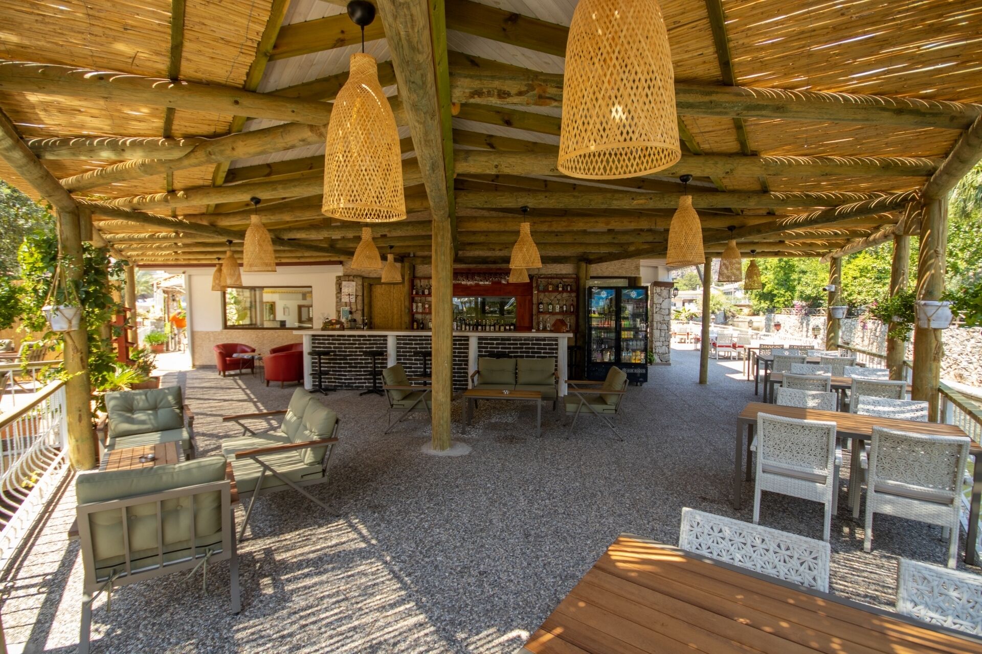 An outdoor seating area with wicker furniture, a bar, and a stone wall.
