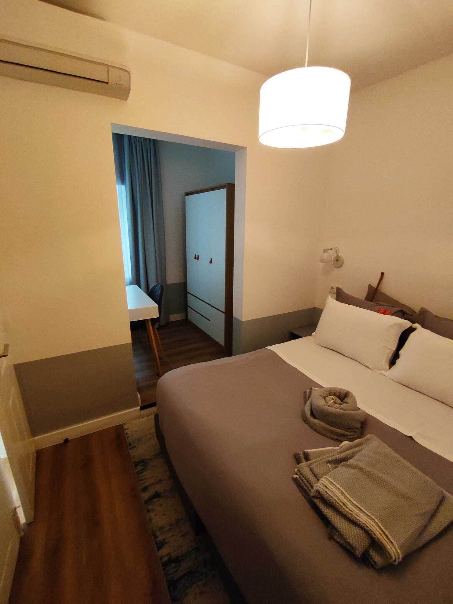Une chambre d’hôtel avec un lit, un bureau et une armoire.
