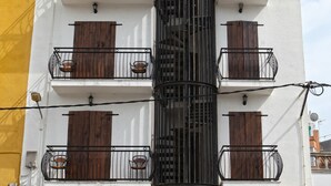 A multi-story building with balconies, a wooden facade, and a sign reading "MIRANDA". - Hostal Miranda (Blanes)