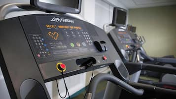 Ein Laufband mit digitaler Anzeige und Bedienfeld, erkennbar als Teil eines Fitnessstudios.