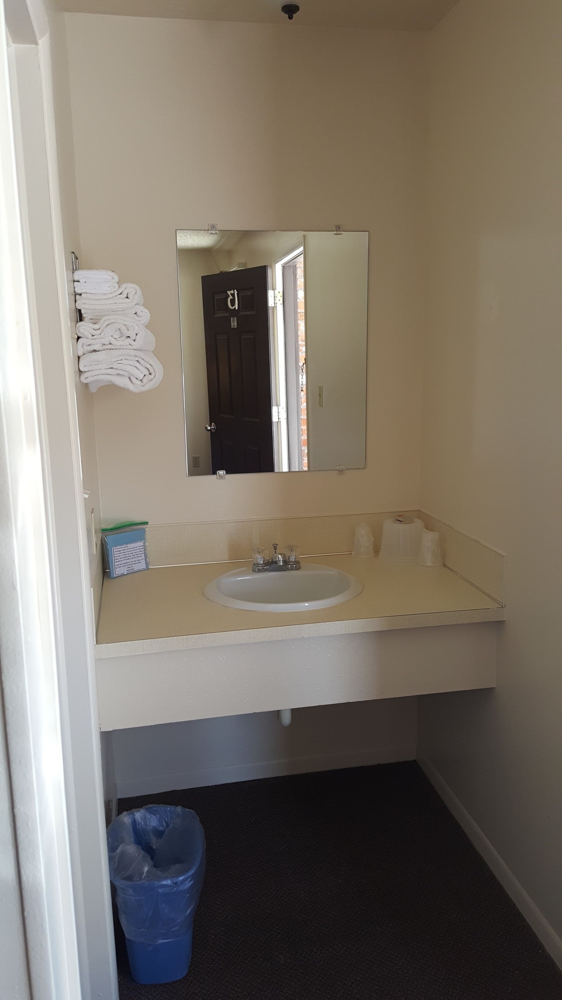 Un bagno piccolo con lavandino, specchio e porta asciugamani.
