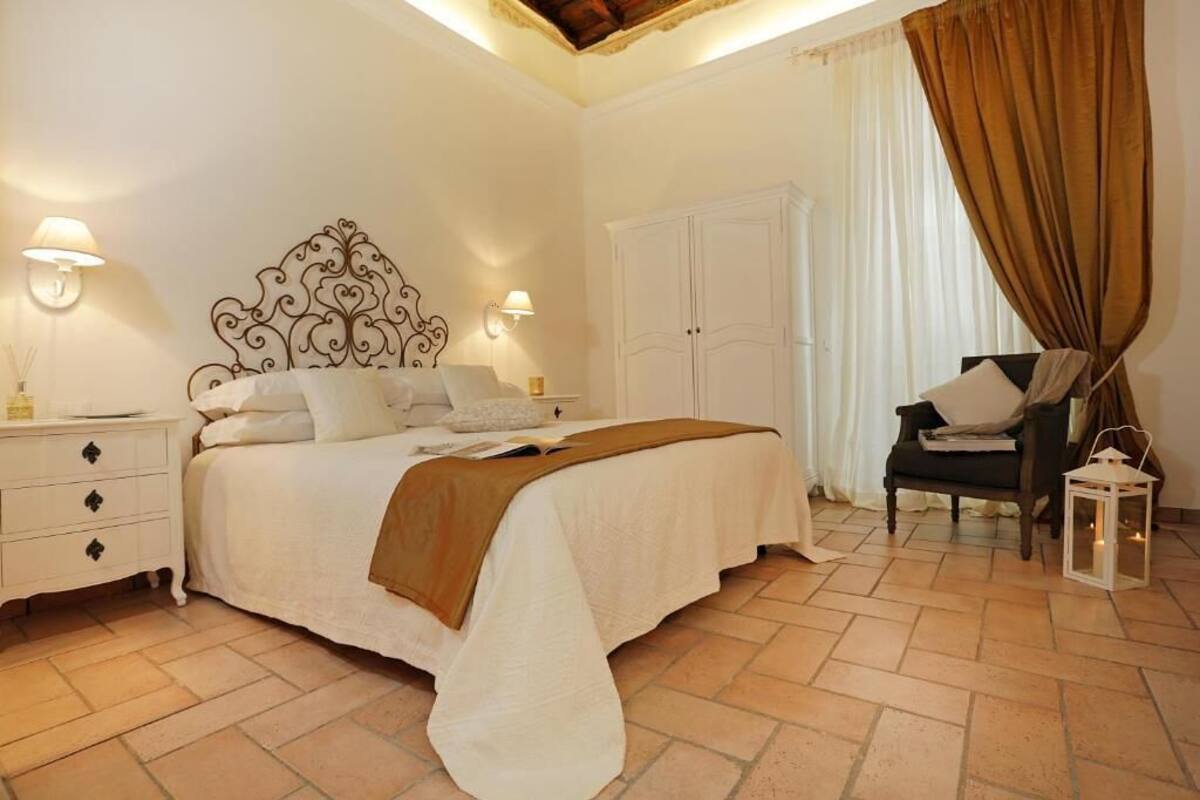 A bedroom with a bed, nightstand, wardrobe, chair, and decorative lantern.
