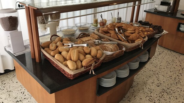 A buffet counter with various breads, pastries, and condiments. - Racó d'en Pepe (Calella)