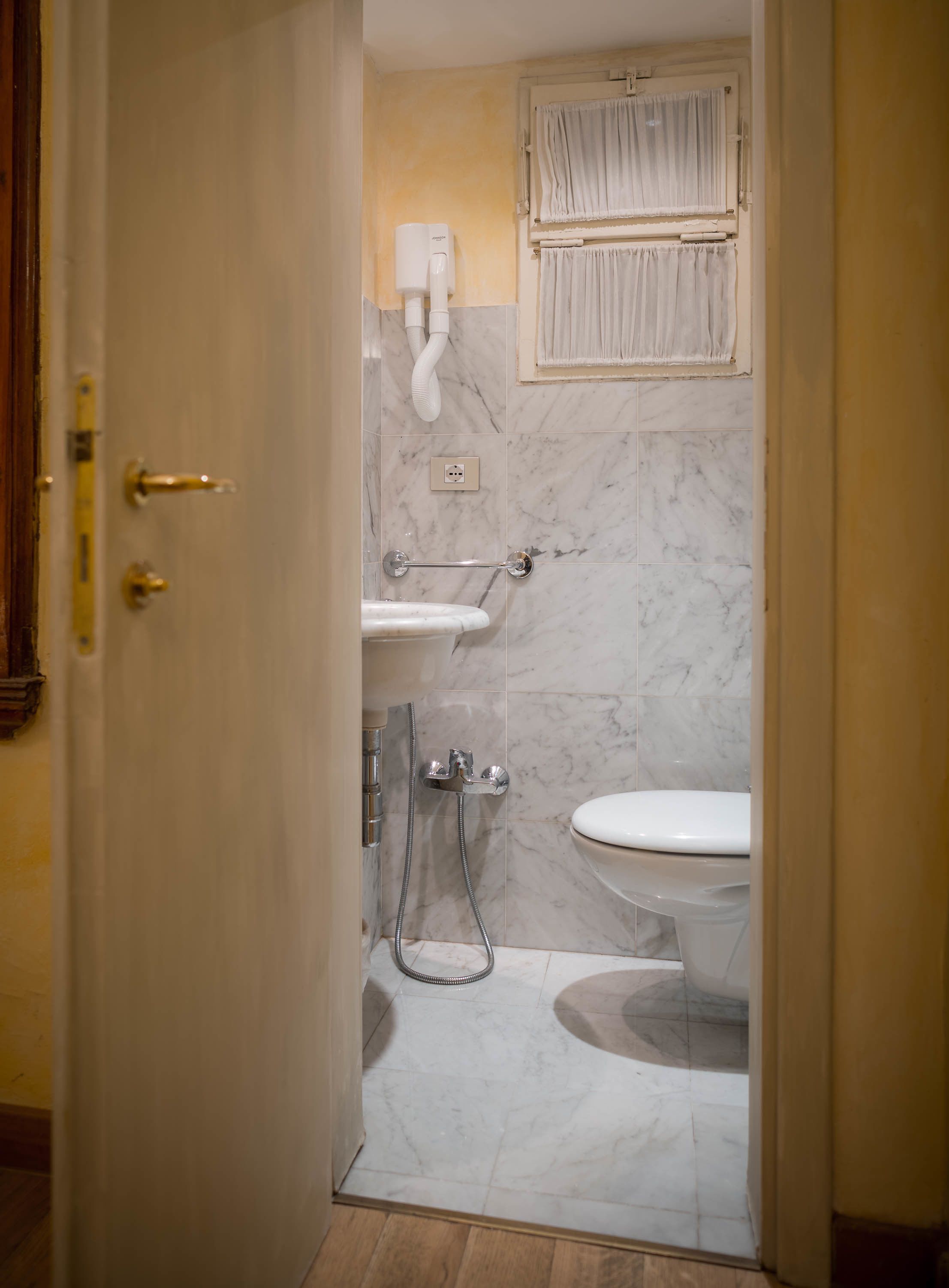 Een badkamer met toilet, wastafel en douche.