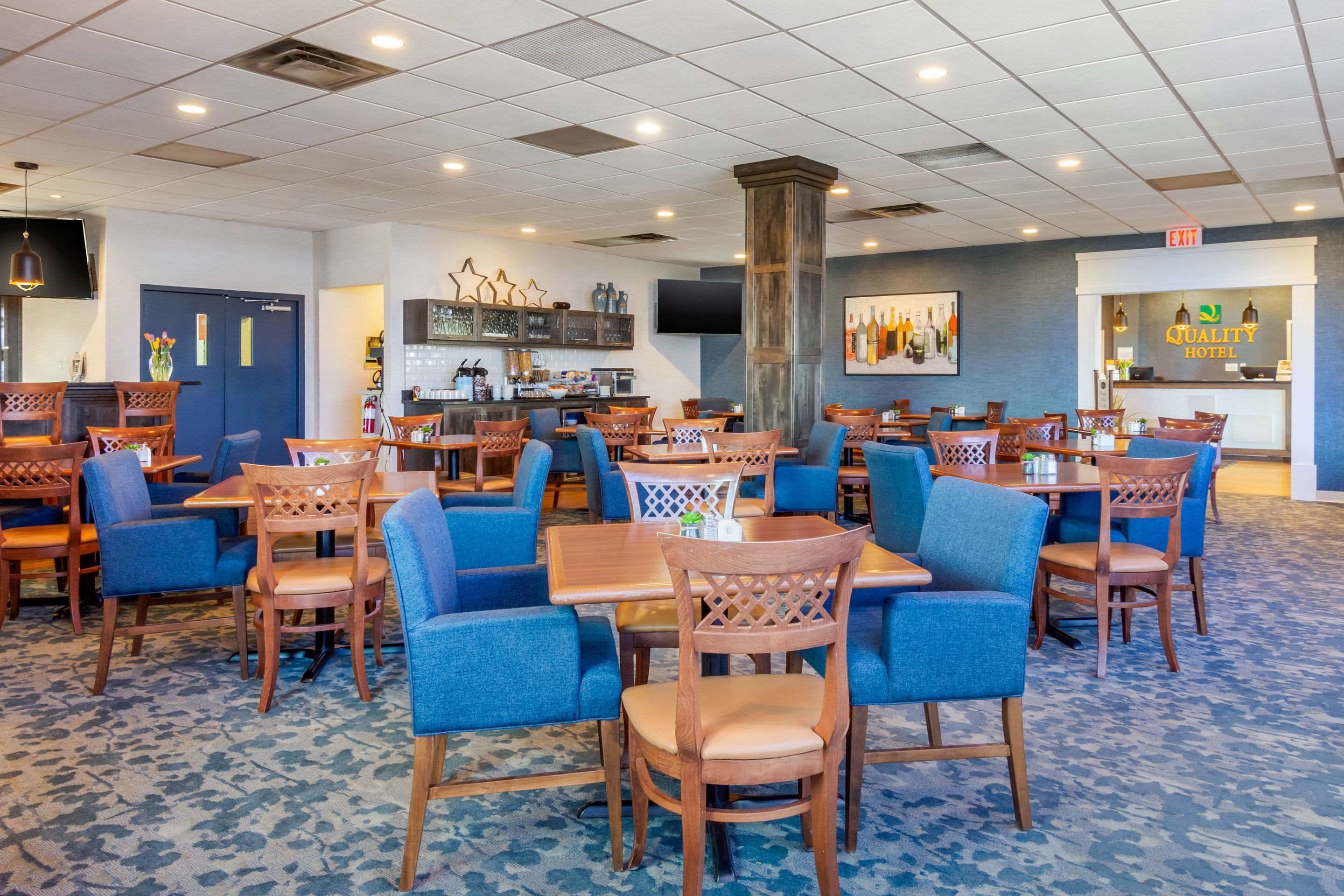 A hotel lobby with multiple seating areas, a bar, and a reception desk.