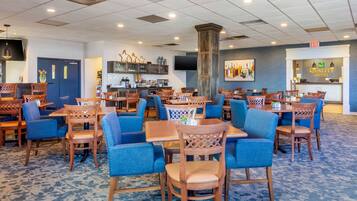 A hotel lobby with multiple seating areas, a bar, and a reception desk.