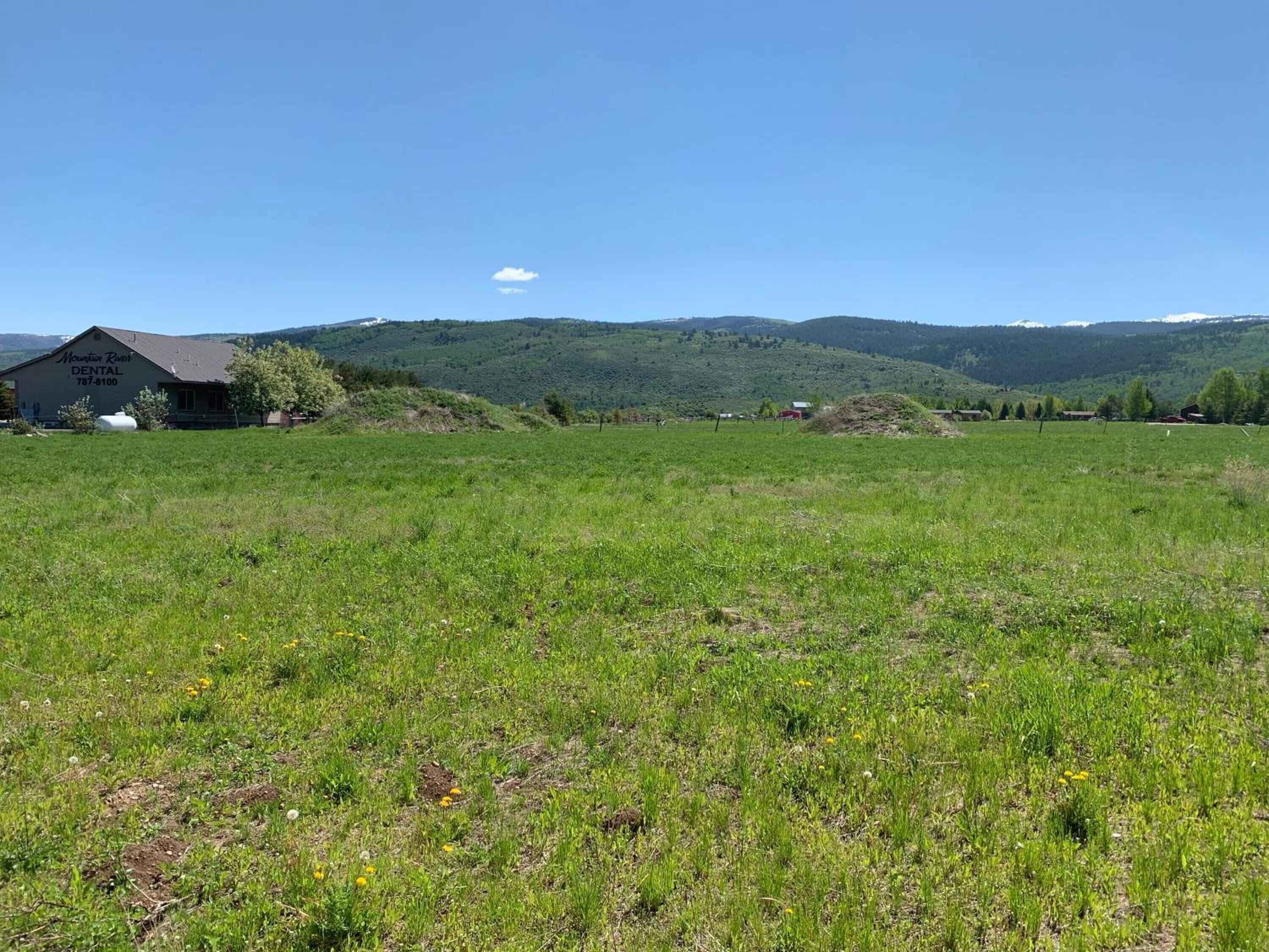 A rural landscape with a building labeled "Mountain River Dental."