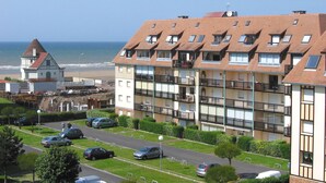 A coastal residential building with multiple balconies, a beach view, and a separate tower-like structure. - Résidence Lagrange Vacances Villers-sur-Mer (Villers-sur-Mer)