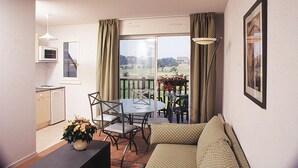 A compact living space with a balcony, a dining table, and a sofa. - Résidence Lagrange Vacances Villers-sur-Mer (Villers-sur-Mer)