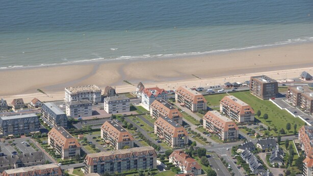 An aerial view of a coastal residential area with apartment buildings, a beach, and a road. - Résidence Lagrange Vacances Villers-sur-Mer (Villers-sur-Mer)
