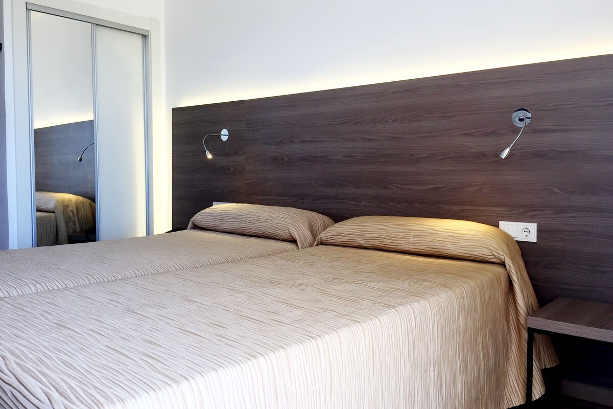 A bedroom with a large bed, two bedside tables, and a wooden headboard.