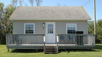 A single-story house with a front porch, a front door, and two windows.