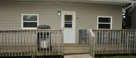 A single-story house with a front porch, a small deck, and a mailbox.