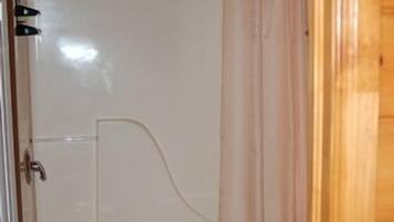 A small bathroom with a shower, toilet, and sink.