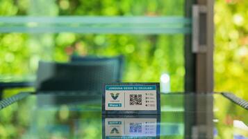 Un código QR sobre una mesa de vidrio con un fondo verde desenfocado.