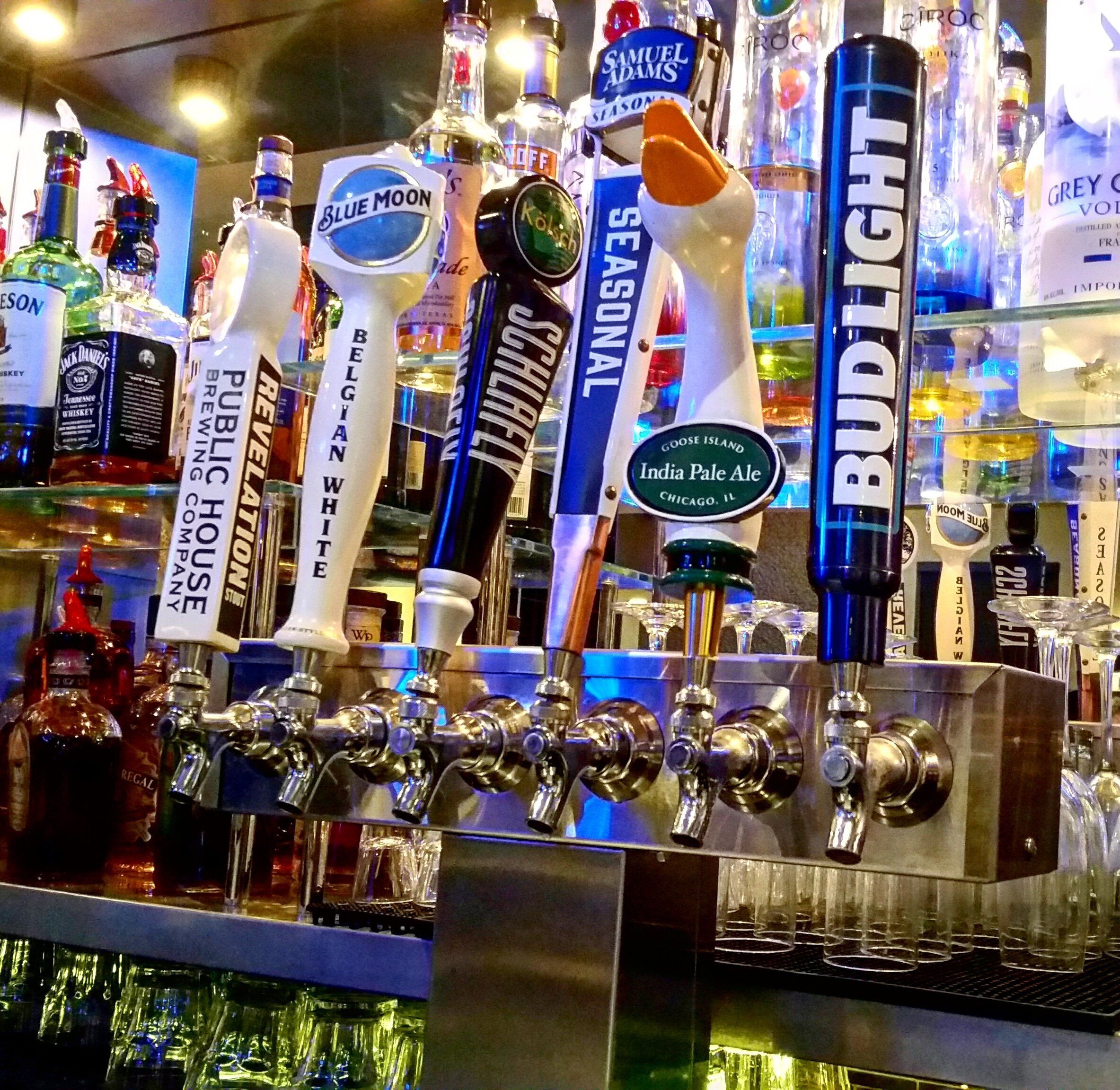 A bar with multiple beer taps, including brands like Blue Moon, Samuel Adams, and Bud Light.