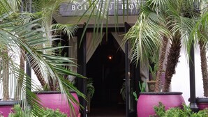 Entrada de un hotel con un camino empedrado que conduce a un interior oscuro.