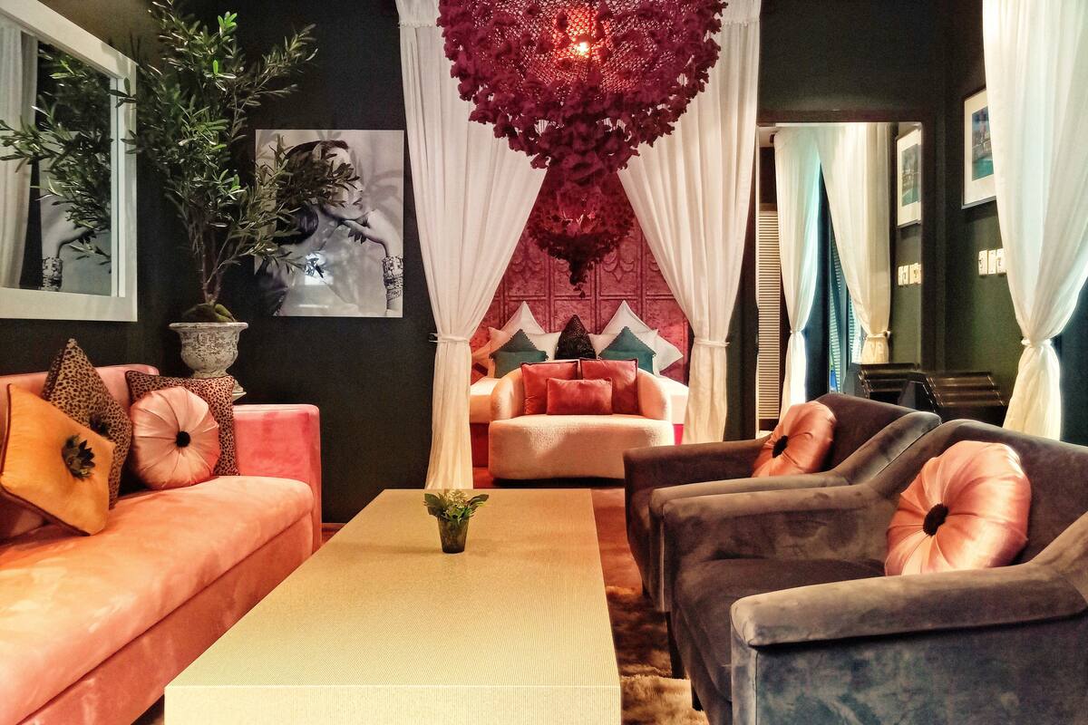 Un salon comprenant un canapé, des fauteuils, une table basse et une grande plante.
