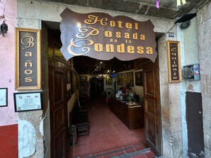 The entrance to Hotel Posada de la Condesa with a wooden facade and a sign above the door.