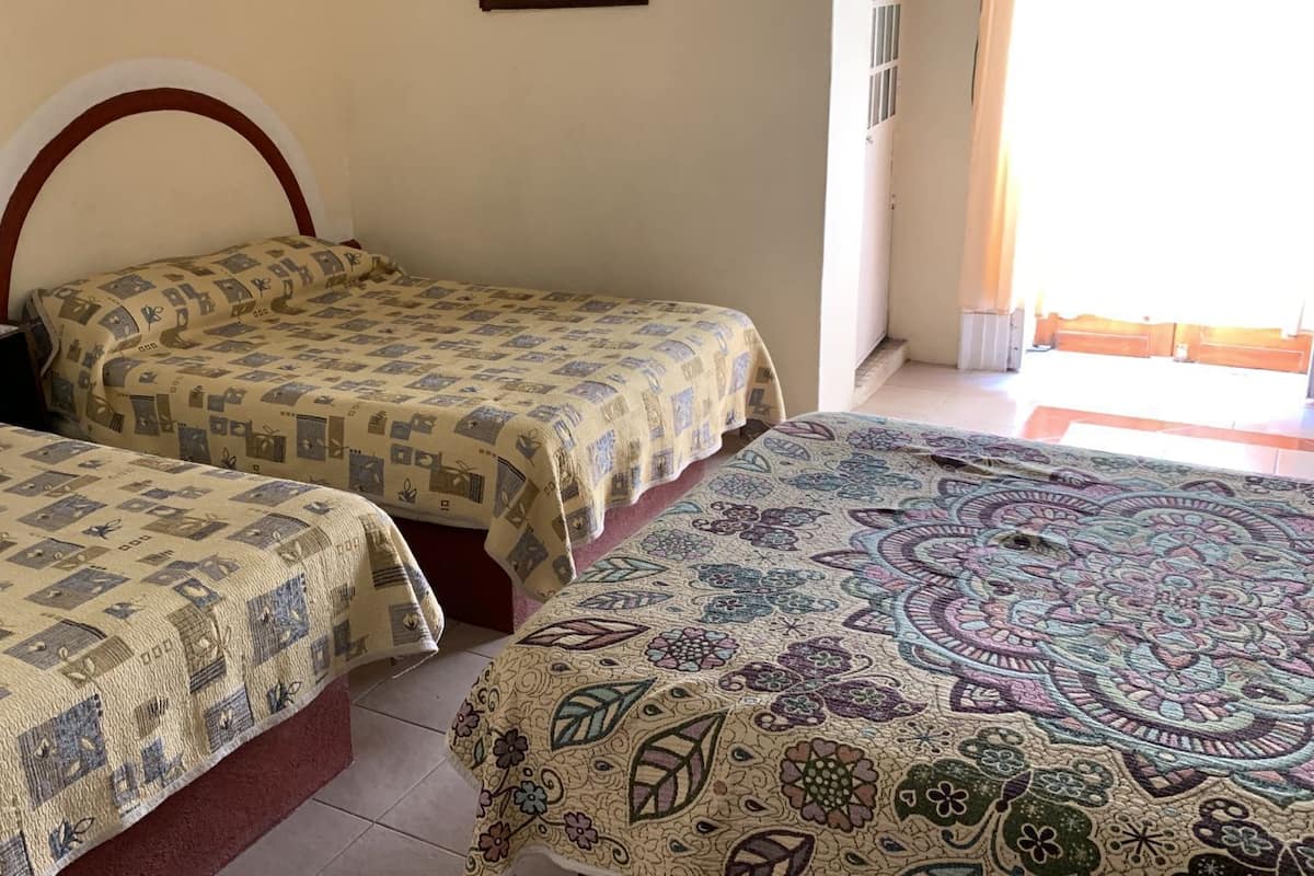 Una habitación con dos camas, cada una con un edredón de diseño diferente.