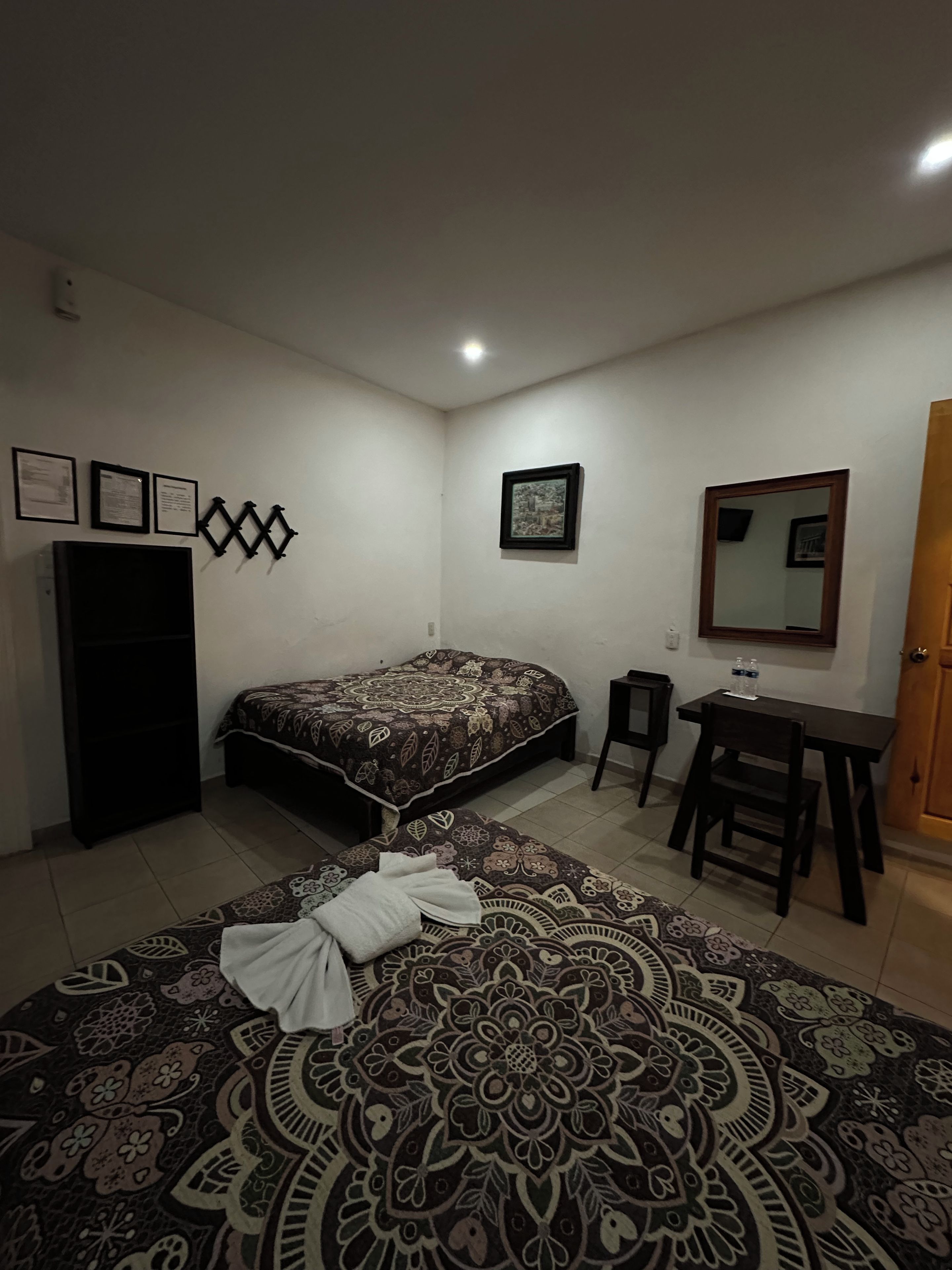 A bedroom with a bed, a desk, a chair, and a wardrobe.