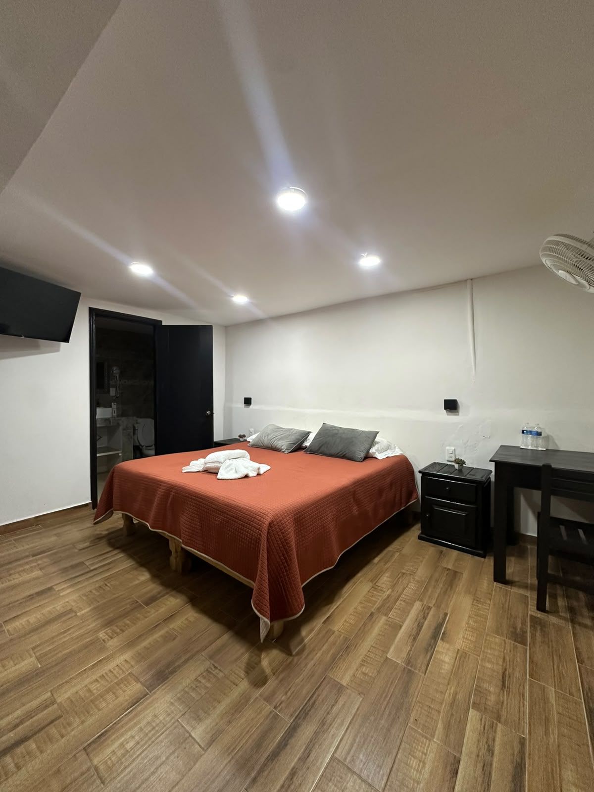 Un dormitorio con cama, escritorio y silla.